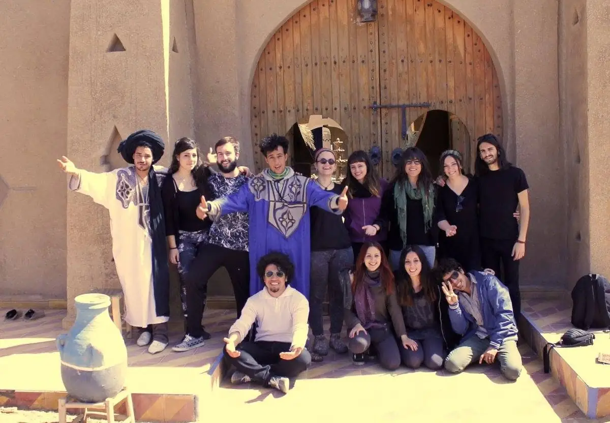 Gruppo di viaggiatori davanti a una porta in terra cruda